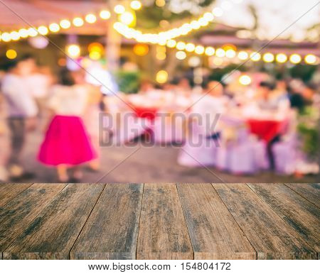 Wood table with blur party background. Abstract blur party background wood table for display your product. Empty wood table and space. Wood board empty table in front of blur party background. Perspective wood table over blur party.