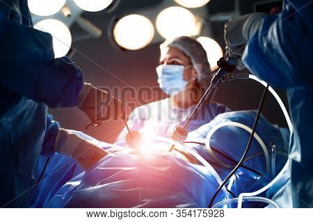 Medical Team Performing Surgical Operation In Modern Operating Room. Working With Surgical Instrumen