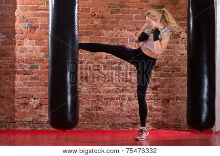 Girl Kicking At Punching Bag