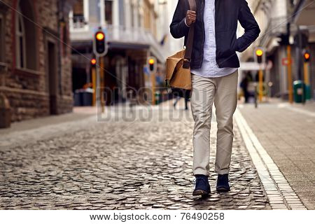 Young african man on vacation exploring european city cobblestone street