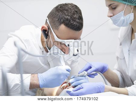 Doctor dentist treats teeth of a beautiful young girl patient. The girl on reception at the dentist. Doctor dentist treats tooth.