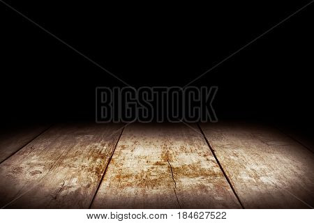 Wood table and black wall background, Empty wooden floor space platform with library background for product display.