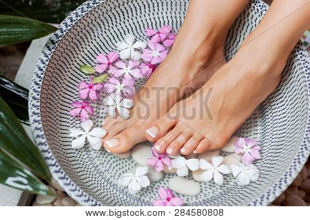 Spa Treatment And Product For Woman Feet And Foot Spa. Foot Bath In Bowl With Tropical Flowers, Thai