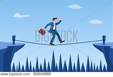 Businessman Is Walking A Tightrope Across The Gap Between The Rocks. Business Concept Risk And Dange