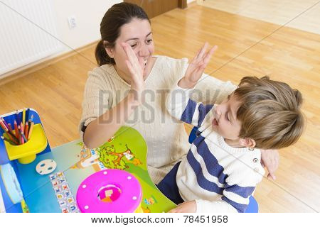 Mother Playing With Her Child And Encouraging Him