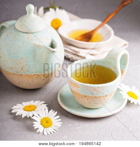 Hot camomille tea with honey in handmade ceramic cup