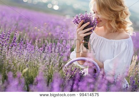 Beautiful woman in a field of blossoming lavender