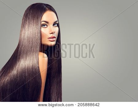 Beautiful long Hair. Beauty woman with luxurious straight black hair on dark background. Beautiful brunette Model girl with Healthy Hair. Lady with long smooth shiny straight hair. Hairstyle, cure