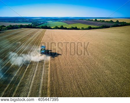 Aerial View On Combine Harvester Gathers The Wheat At Sunset. Harvesting Grain Field, Crop Season. V