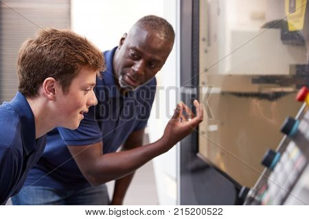 Engineer Showing Apprentice How To Use CNC Tool Making Machine