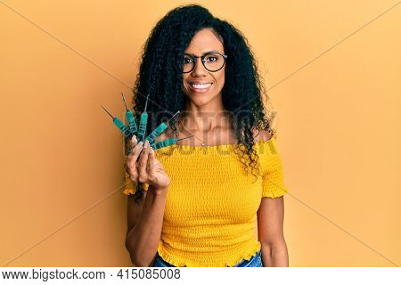 Middle age african american woman holding picklock to unlock security door looking positive and happy standing and smiling with a confident smile showing teeth 