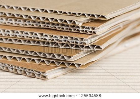 Cardboard pile on corrugated cardboard texture. Industrial background.