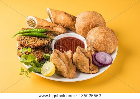 coriander vada or kothimbir vada, samosa, kachori, daal vada on brown wooden planks. indian assorted snacks. Indian snacks combination. Indian snacks group, indian favourite snacks, asian spicy snacks