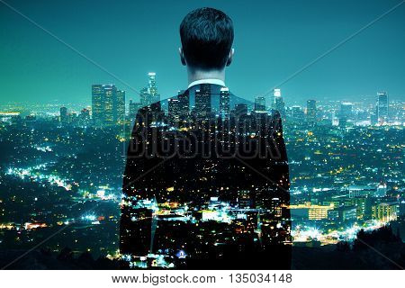 Businessman looking at illuminated night city. Double exposure