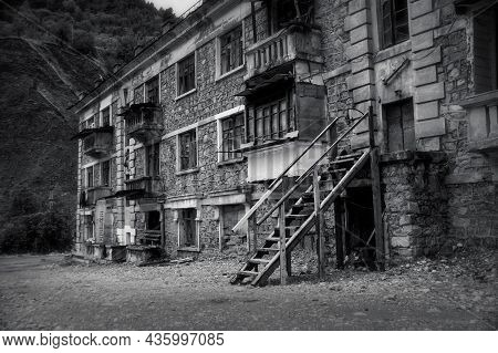 Black And White Photo Of Old Abandoned Building In Ruined By Mudflow Small Town High In Mountains Wi