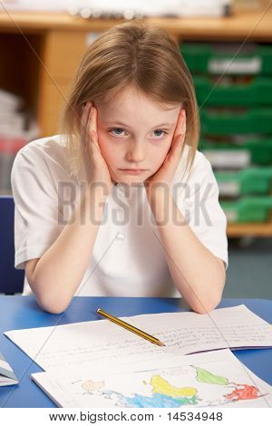 Stressed Schoolgirl Studying In Classroom