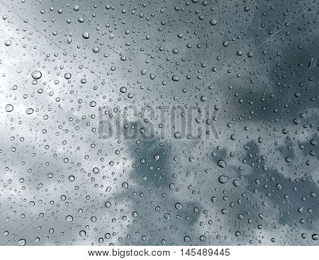 Drops of rain on glass , rain drops on clear window / rain drops with clouds / water drops on glass after rain background / water drops / Small water drops on the glass