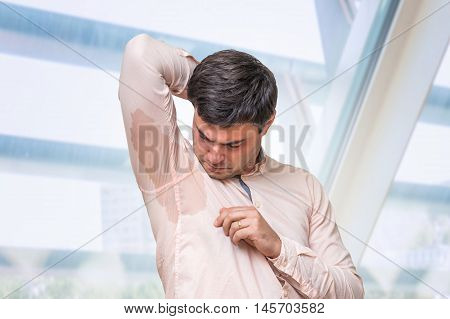 Man With Hyperhidrosis Sweating Under Armpit In Office