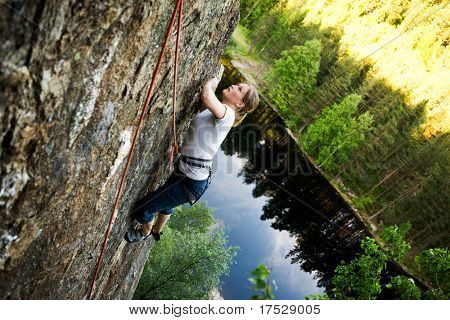 次の保持のための急な岩の顔の女性登山。フィールドの浅い深さのため