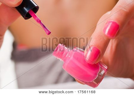 Woman applying red nail polish