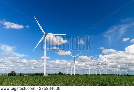 Windmills For Electric Power Production In  Cassava Field On Blue Sky At Huai Bong, Dan Khun Thot Di