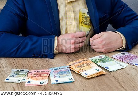 Euro Banknotes In Male Hands And On Table