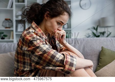 Young Girl Is Deep In Sad Thoughts, Thinks, Looks Away, Feels Tense And Unhappy. Brunnete Woman Sitt