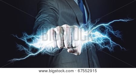 Businessman holding lightning in fist. Power and control