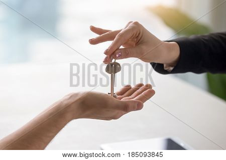 Real estate agent giving keys to apartment owner, buying selling property business. Close up of male hand taking house key from realtor. Mortgage for purchasing flat, getting access to own home