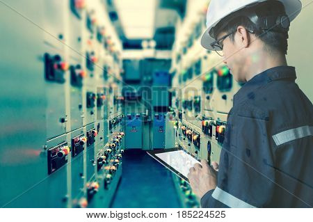 Double exposure of Engineer or Technician man working with tablet in switch gear electrical room of oil and gas platform or plant industrial for monitor process business and industry concept