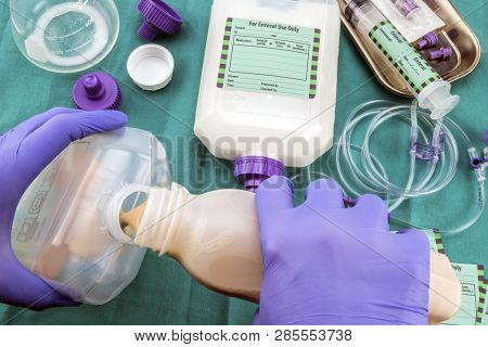 Nurse Filling A Bottle Of Enteral Nutrition, Palliative Care, Conceptual Image, Horizontal Compositi