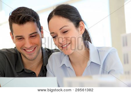 Happy young couple signing property purchase contract