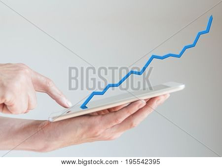 Concept of increasing sales from mobile online shopping with hand holding tablet