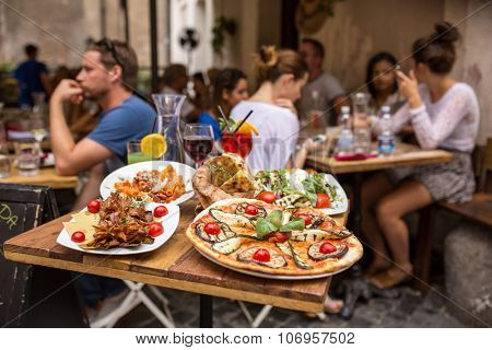 Rome, Italy - September 11, 2015: Unidentified people eating traditional italian food in outdoor restaurant in Trastevere district in Rome, Italy.