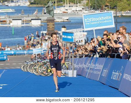 STOCKHOLM - AUG 26 2017: Running triathletes Jonathan Brownlee and smiling hand clapping audience in the background in the Men's ITU World Triathlon series event August 26 2017 in Stockholm Sweden