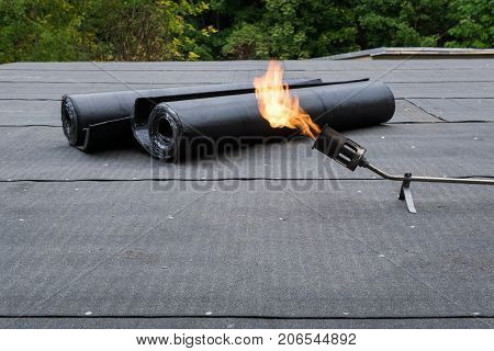 Heating and melting bitumen roofing felt Flat roof installation.