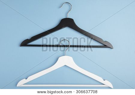 Black And White Hangers Interlocked With Each Other On Blue Background. Concept View.