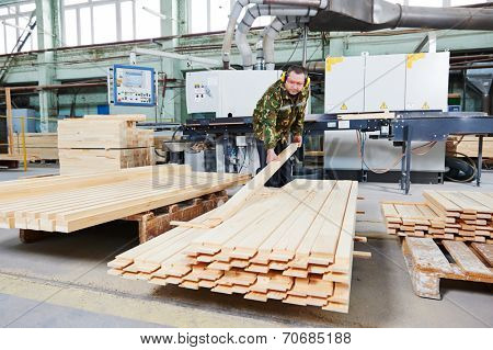 Worker of wood processing manufacture operating on woodworking machine