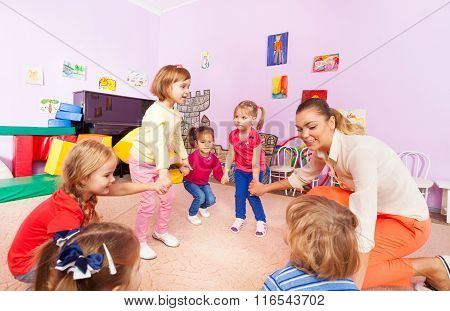 Little children boys, girls squat play roundelay