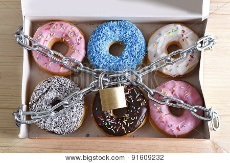 Box Full Of Tempting Delicious Donuts Wrapped In Metal Chain And Lock In Sugar And Sweet Addiction