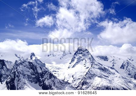 Snowy Mountains In Clouds At Sun Day