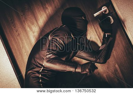 House Security Concept with Home Burglar in Action Trying To Break Into the House.