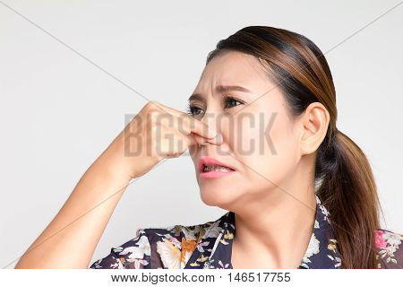 Asian woman closing her nose because she smelly