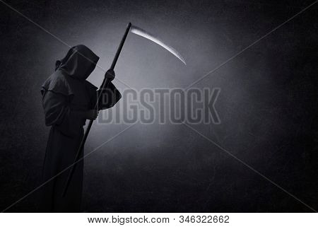 Grim reaper with scythe in the dark