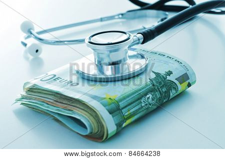 a stethoscope on a wad of euro bills, depicting the concept of the health care industry or the health care costs