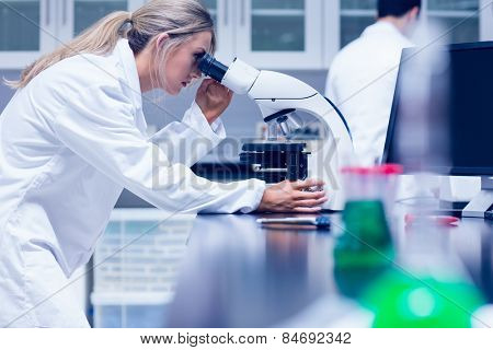 Science student working with microscope in the lab at the university