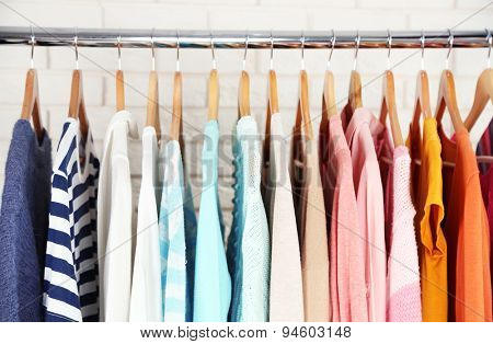 Different clothes on hangers close up