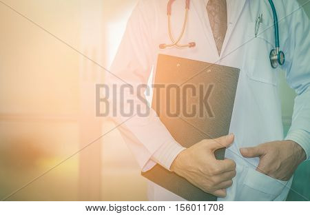 close up of patient and doctor taking notes vintage tone. Doctor man. Doctor woman. Tool doctor. Uniform doctor. Clipboard in hand doctor.