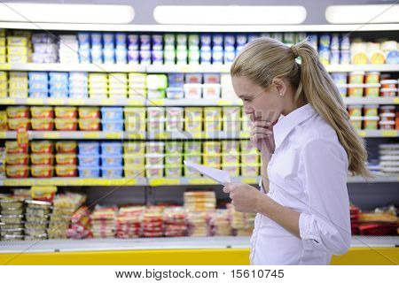 vrouw leest haar boodschappenlijstje in de supermarkt met kopie ruimte