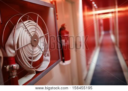 Fire extinguisher and fire hose reel in hotel corridor